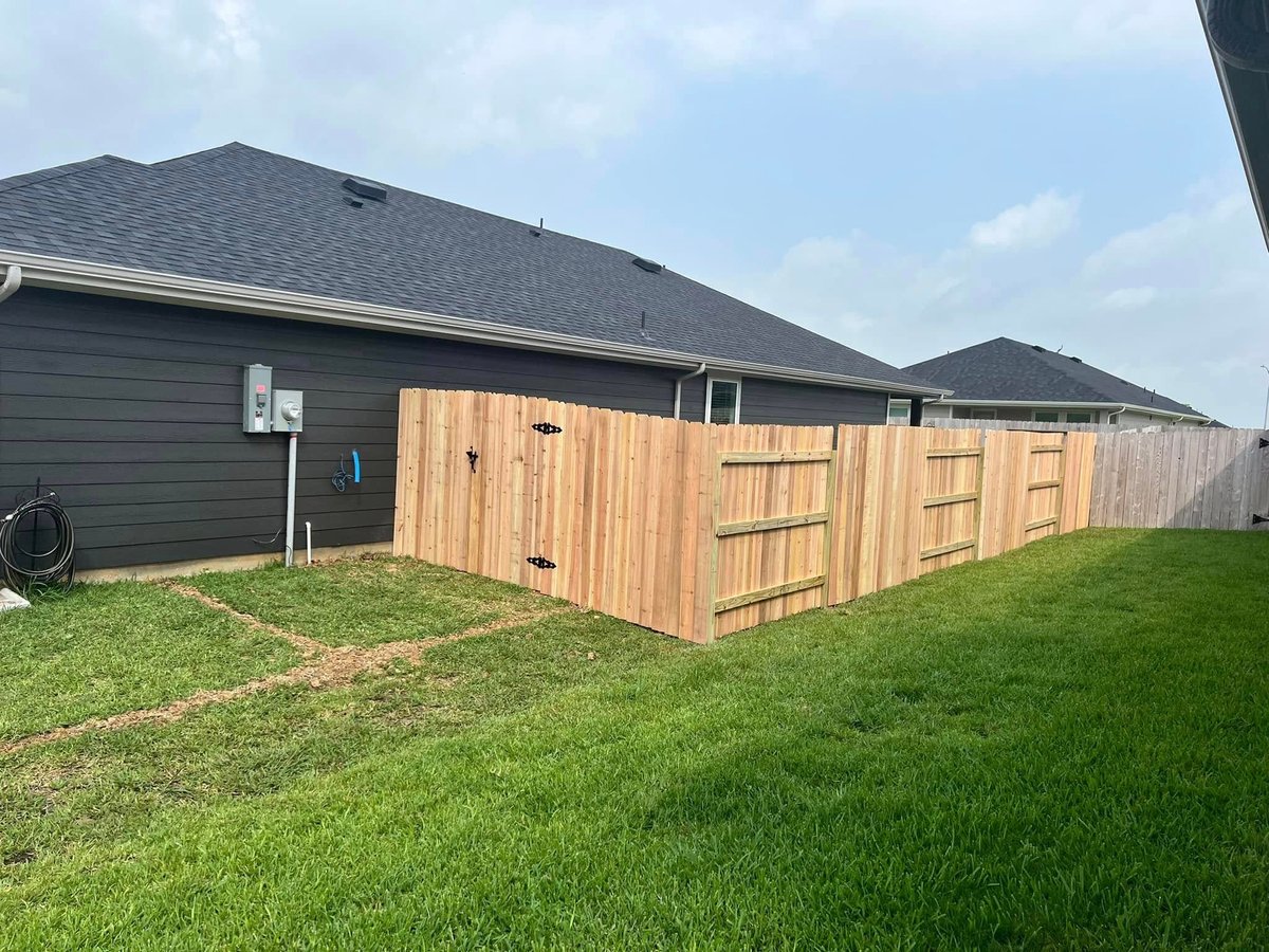 Tall wooden privacy fence with custom gate around a backyard shed in Brookshire TX